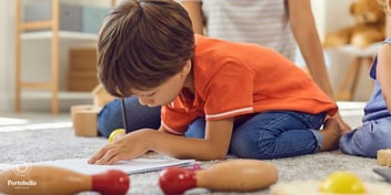 young child drawing on the floor