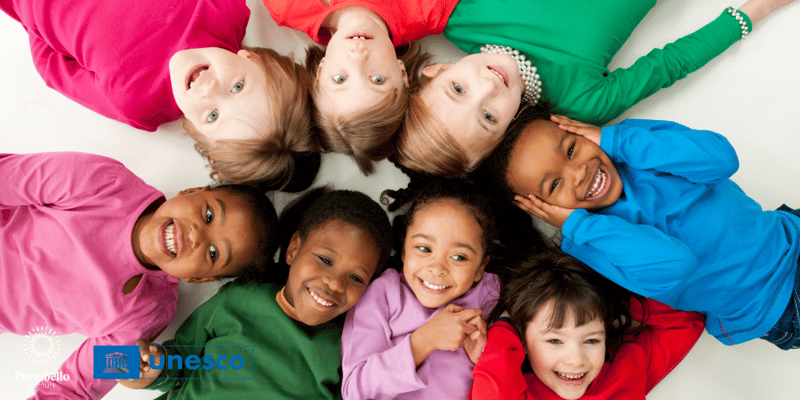 Children lying in a circle smiling UNESCO logo