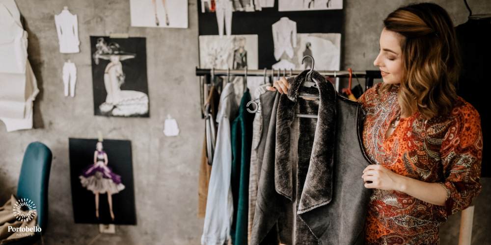 Woman holding a jacket in front of a rail of clothes