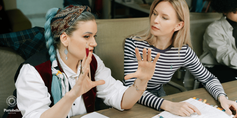 One woman talking and another woman listening in a business meeting setting