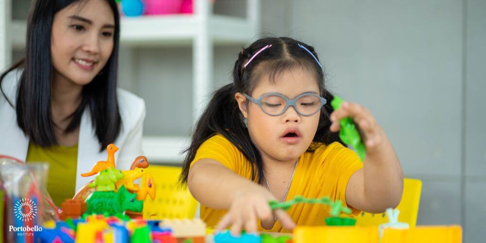 child playing with block teacher supporting in the background