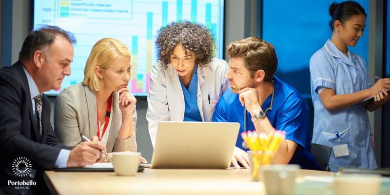 healthcare workers at a table looking at a laptop