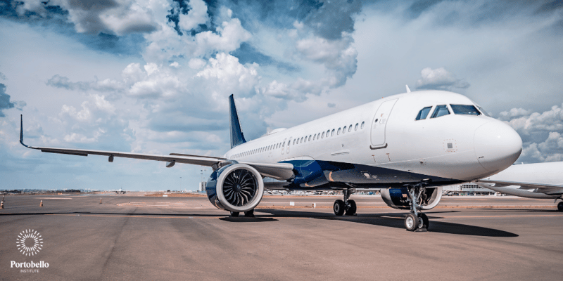 An airplane on a runway with blue sky in the background