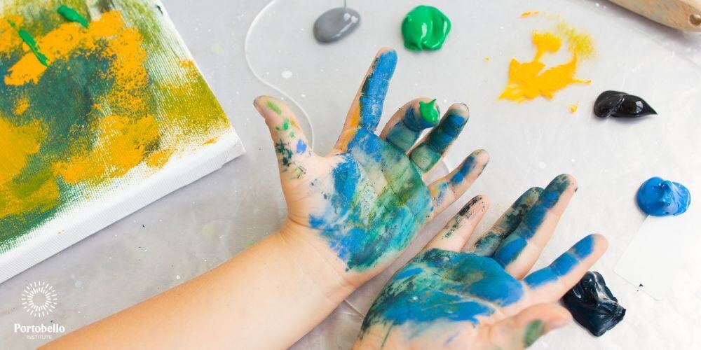 a picture of a child's hands with green, blue and yellow painted palms