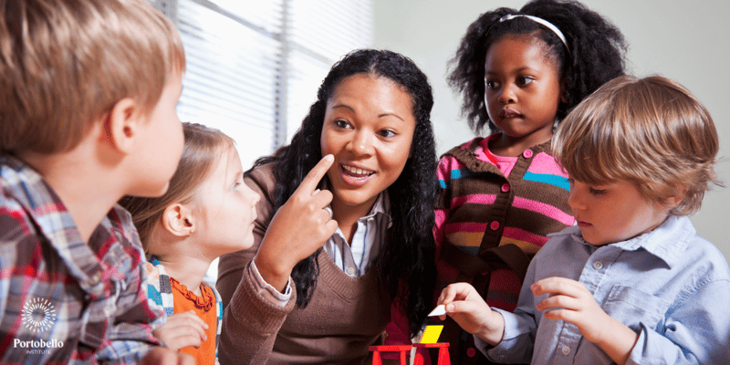 preschool teacher smiling and working with small children