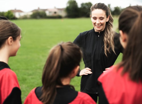 PE Teacher coaching children