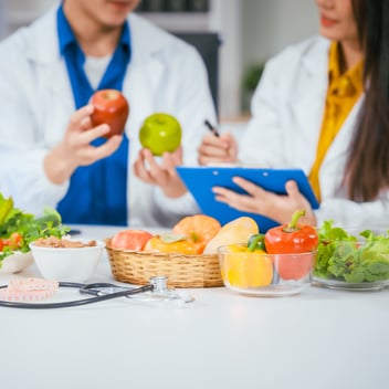 Two professional dietitians work together surrounded by food