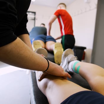 Physiotherapist touching a patient's leg