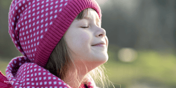 a young girl with her eyes closed in the sunlight