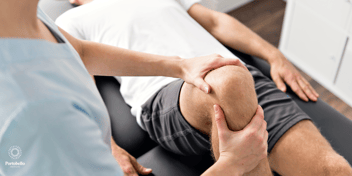 sports therapists working on a man's knee