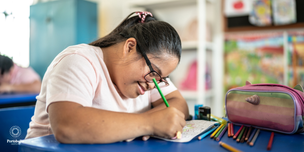 student sitting in class writing on paper with a pencil