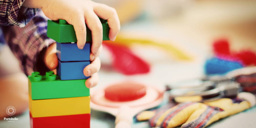 A close up of a child's hands on colourful plastic blocks