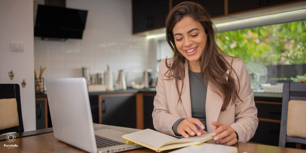 woman studying with a notebook and laptop in a kitchen 