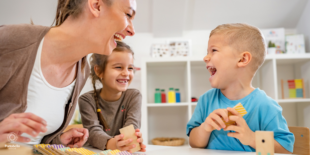 a preschool teacher laughing with two young children