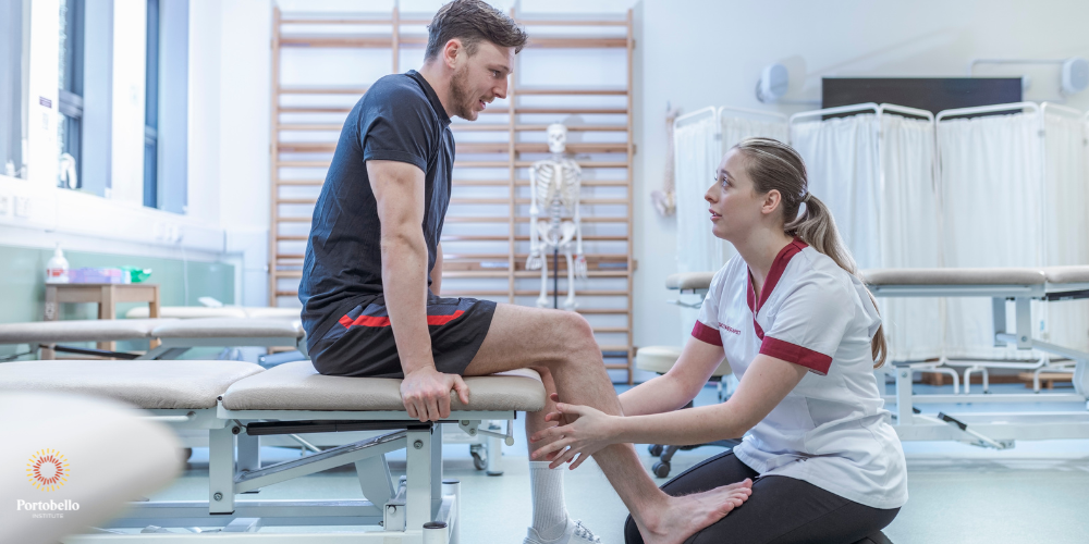 patient sitting on bed getting massage from physiotherapist