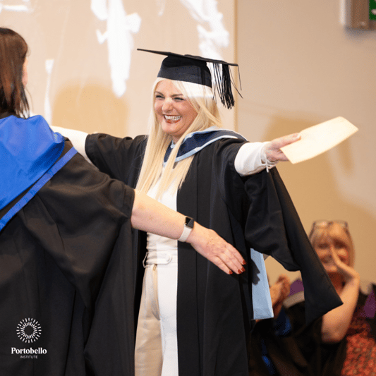 Graduate smiling and celebrating receiving their Certificate at a graduation ceremony