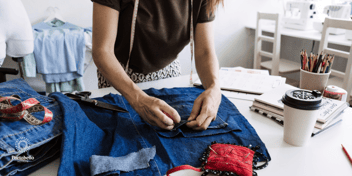 Woman sewing piece of clothing.