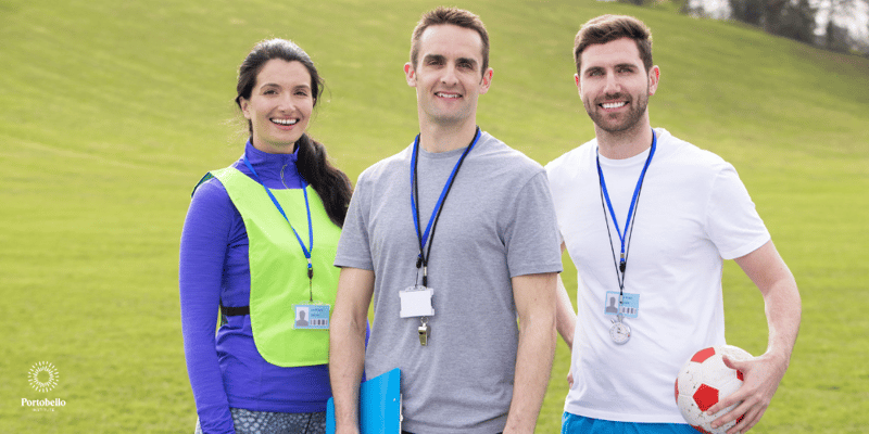 Three PE teachers standing on a pitch