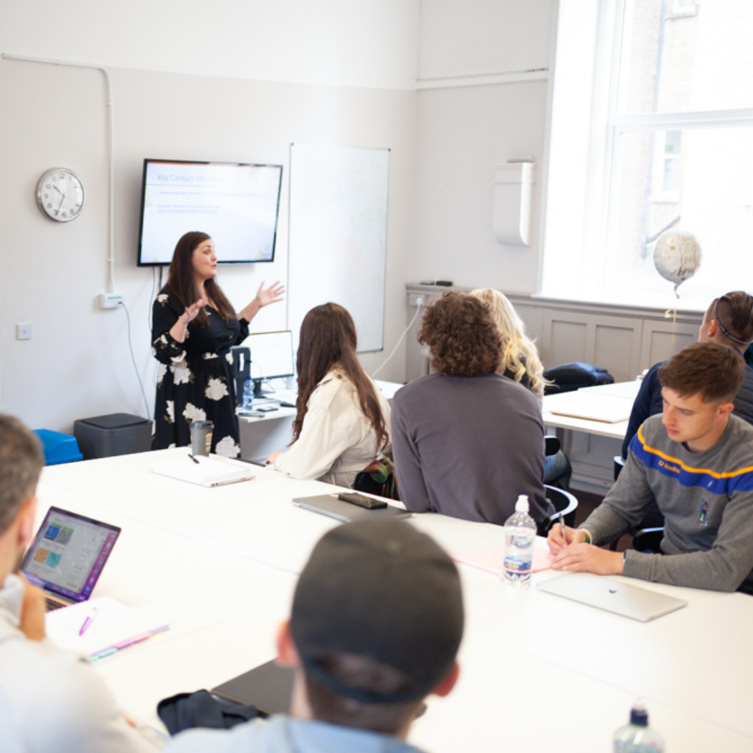 Portobello Institute students sit in a classroom for programme induction led by their tutor