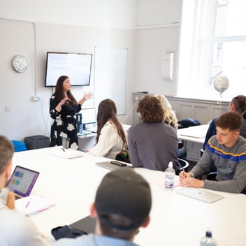 Portobello Institute students sit in a classroom for programme induction led by their tutor