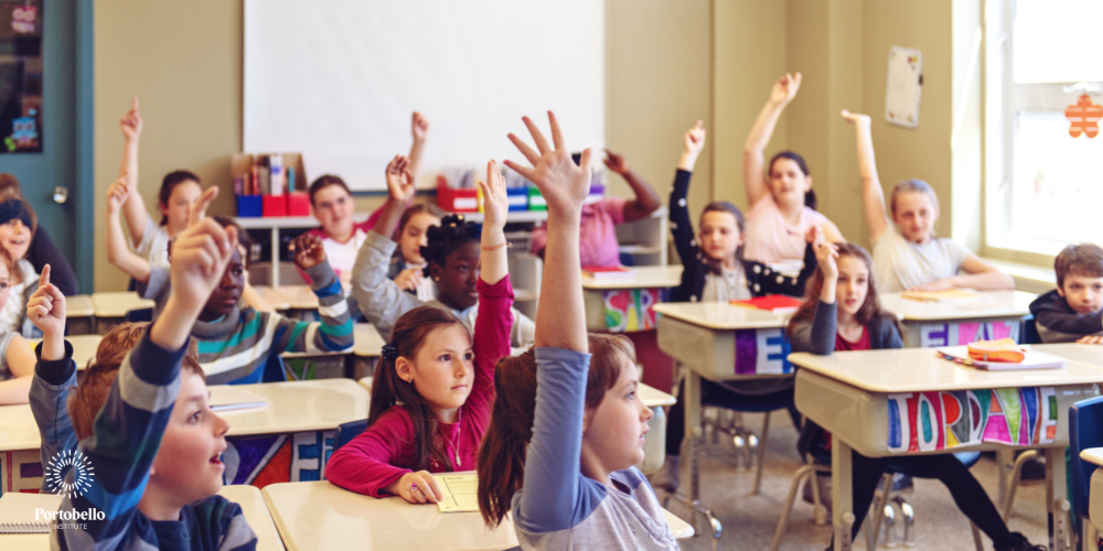 classroom full of children with their hands up