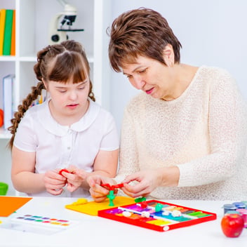 Special needs assistant supporting a young girl