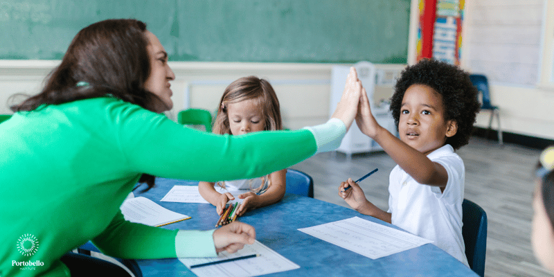 a teacher high fiving a child in a classroom