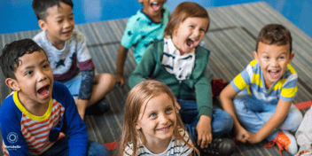 preschool children sitting cross-legged and smiling