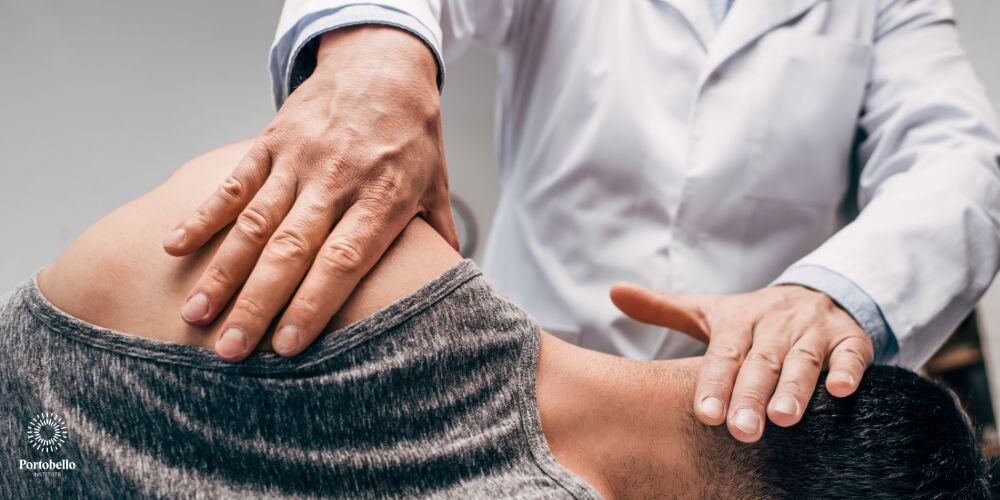 A chiropractor with his hands on a client's neck and head lying down