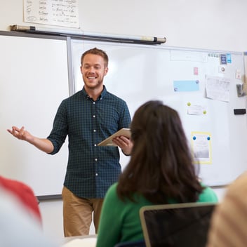 Male teacher in a post-primary school setting speaks to his class