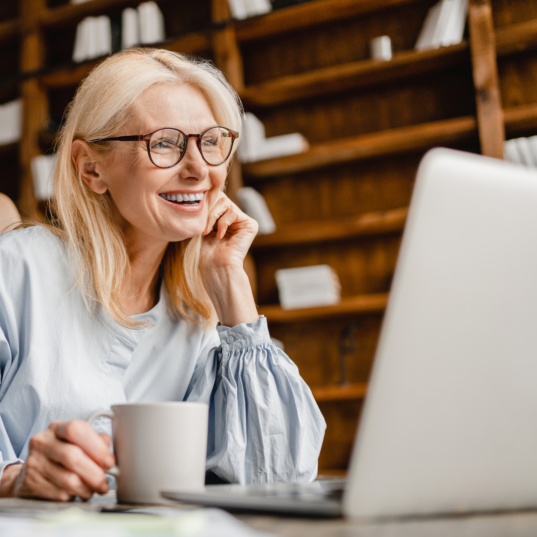 Smiling woman with laptop studying online