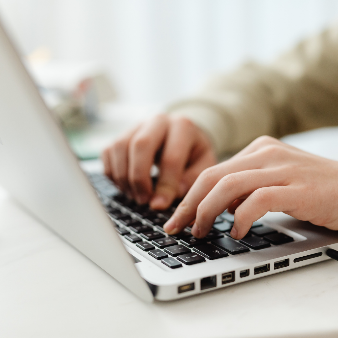 A close up of someone typing on a laptop