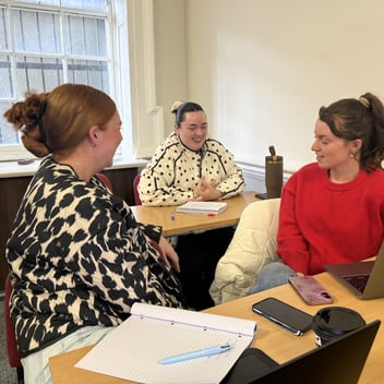 Three Portobello Institute students sit together in class to discuss their learning