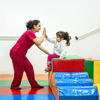 Occupational therapist celebrating a milestone with a young child