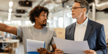 two men talking working in facilities management holding documents