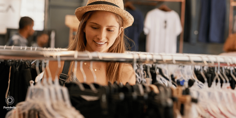 a woman looking at clothes hanging on a rail