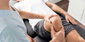 A physiotherapist working on a man's knee