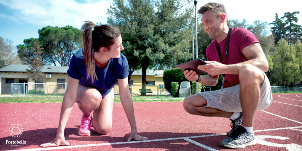 Sports coach working with a running on an athletics track