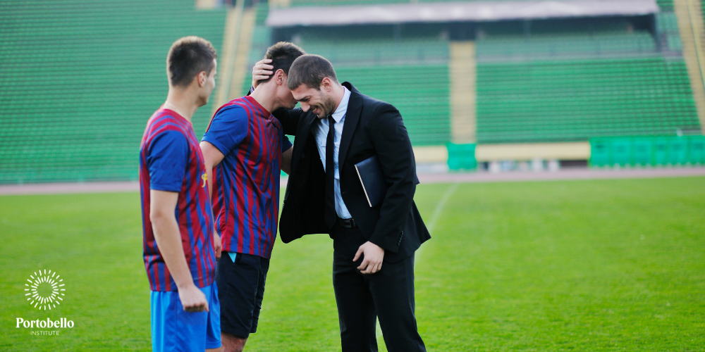 sports manager with two players on a pitch